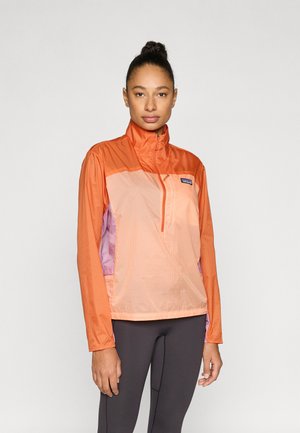 Leichte Halb-Reißverschlussjacke in Orange und Pfirsich mit lila Akzenten. Hergestellt aus einem glatten, atmungsaktiven Material mit Stehkragen.