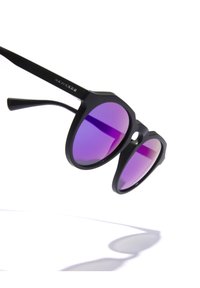 Černé sluneční brýle s hexagonálním rámem, vybavené gradientními fialovými skly a přímými černými stranami. Pozoruhodné svým vysoce odlišným designem a texturou.