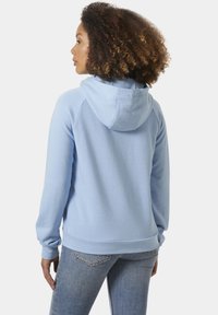 Sudadera con capucha de color azul claro, con una textura suave, mangas raglán y puños de canalé. Cuenta con una capucha ajustable y un corte relajado.