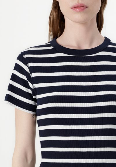 T-shirt à rayures bleu marine et blanches à manches courtes, avec une texture côtelée et un col rond ; design ajusté avec des détails de couture visibles.