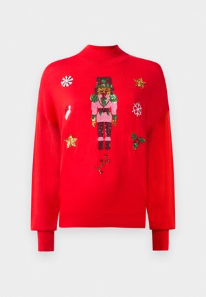 Maglione rosso con un schiaccianoci lavorato a maglia, stelle dorate, caramelle di menta, cappello di Babbo Natale, fiocco di neve, agrifoglio e decorazioni a paillettes di albero di Natale.