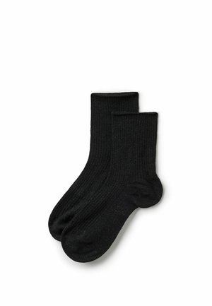 Paar schwarze, gerippte, knielange Socken flach ausgelegt, wobei ein Socken leicht den anderen überlappt, auf weißem Hintergrund.