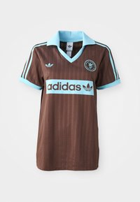 Hnedý športový dres s svetlomodrým golierom a pruhovanými akcentmi. Logo "Adidas" výrazne umiestnené na hrudi.
