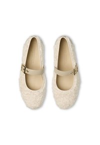 Scarpe in morbido tessuto di colore crema, con punta arrotondata, caratterizzate da una ampia cinghia beige con fibbia dorata che attraversa il ponte del piede.