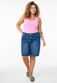 Jeansshorts i mörkblått med en avslappnad passform, med en framknapp, dragsko i midjan och uppvikta fållar. Matchas med en ljusrosa linne.