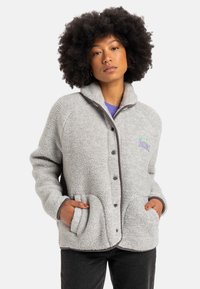 Gray fleece jacket with a collared neck, button front, two front pockets, and contrasting dark trim. Features embroidered detailing.