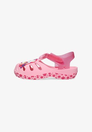 Sandalo rosa per bambini con suola decorata a stelle, cinturino regolabile e ciondolo decorativo colorato sul davanti.