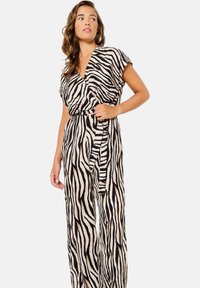 Mono de estampado de cebra en beige y negro, con un profundo escote en V, mangas cortas, cintura ceñida con cinturón y piernas anchas. Tejido ligero con una caída fluida.