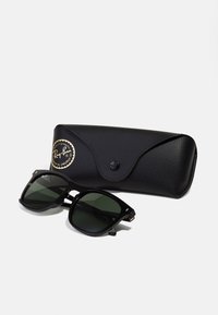 Black rectangular sunglasses with dark lenses, metal accents, and Ray-Ban logo, alongside a textured black case with a circular logo.