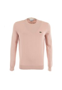 Pull en tricot rose clair avec un col rond, des manches longues et des poignets côtelés. Dispose d'un logo crocodile brodé vert sur la poitrine.