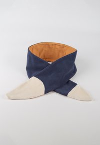Scarf in pile bicolore con esterno blu navy, interno color sabbia e punte a forma di triangolo beige chiaro, incrociati su uno sfondo bianco.