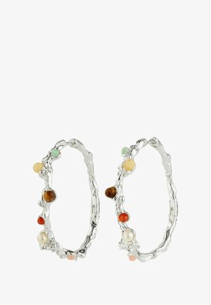 Srebrni obroči z valovitim vzorcem in različnih barvnih kroglicah, vključno z oranžno, rjavo, zeleno in kremasto, razporejenih ob robovih.