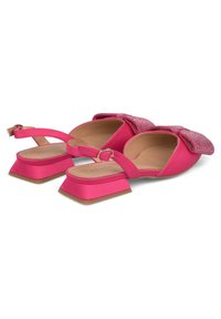 Scarpe con tacco a blocco in satin rosa con cinturino alla caviglia e un dettaglio a fiocco scintillante sulla parte anteriore. Suola piatta con un finish testurizzato.