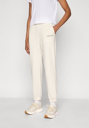 Pantaloni jogger color crema con gamba affusolata, tasche laterali e polsini elasticizzati. Presentano il logo "BJÖRN BORG" con un carattere a contrasto sull'anca sinistra.