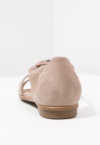Jasnobrązowe zamszowe baleriny o otwartej konstrukcji, z wycięciami, okrągłym noskiem i niskim, przezroczystym gumowym obcasem.