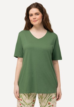 T-shirt verde a maniche corte con scollatura a V realizzato in tessuto morbido, abbinato a pantaloni con motivo floreale nei toni del rosso e del verde.