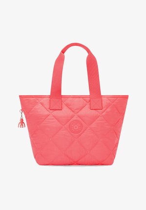 Quilted tote bag in bright coral with fabric straps. Features a round logo and a charm accessory. Smooth texture with a structured shape.