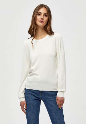 Weißer Langarmpullover mit rundem Halsausschnitt, gerippten Bündchen und eng anliegender Passform. Kombiniert mit blauen Jeans. Glatte Textur, minimalistisches Design.