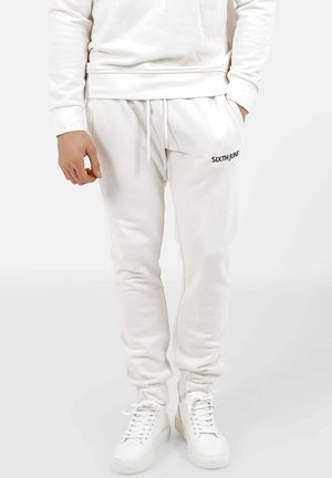 White cotton joggers with elastic waistband and cuffs, featuring side pockets and black "SIXTHJUNE" branding on the left thigh.