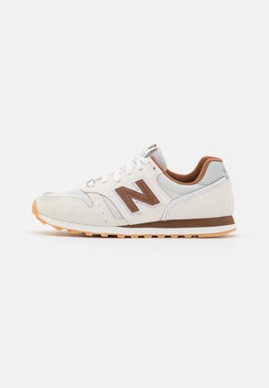 Biało-brązowy sneaker New Balance z cholewką z siateczki i zamszu, gumową podeszwą oraz sznurowaniem, pokazany z profilu na białym tle.
