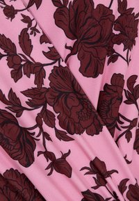 Kwiatowy materiał z dużymi burgundowymi kwiatami i liśćmi na różowym tle; gładka faktura z delikatnym połyskiem.