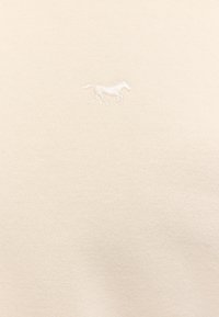 Kremowy pulower o miękkiej fakturze, z małym białym haftowanym logo konia na piersi.