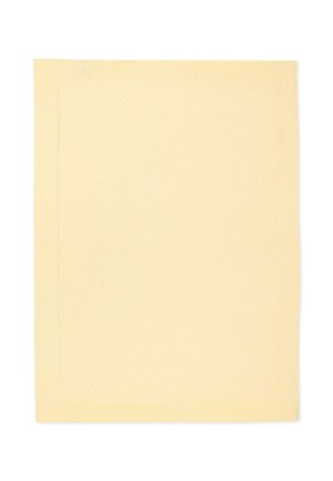 Tissu rectangulaire jaune doux avec une bordure simple surpiquée et un petit logo brodé dans un coin.