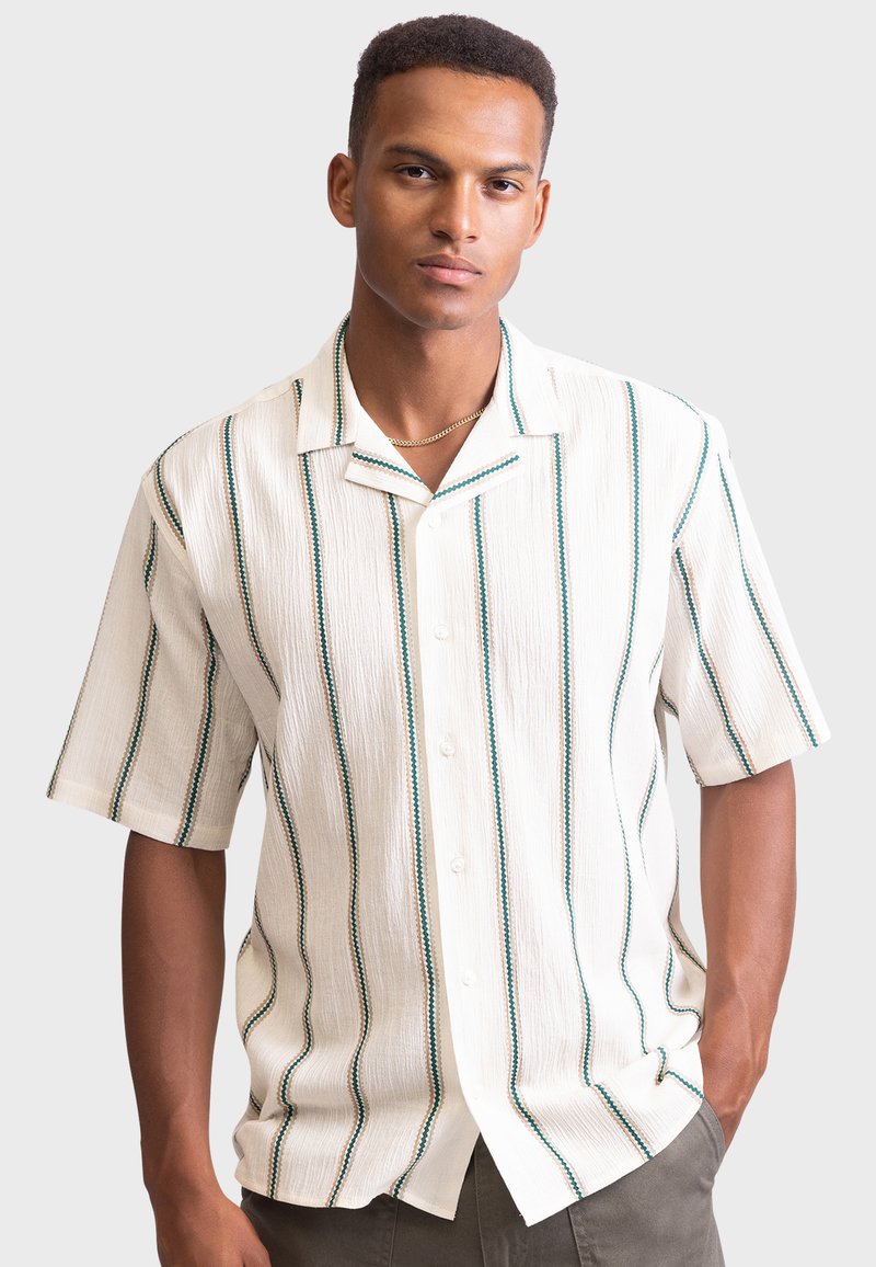 Chemise à manches courtes à boutons en crème avec des rayures verticales vertes, tissu texturé et col décontracté.