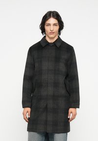 Sort og gråternet frakke med kravehalvdel, knaplukning, sidelommer og lige snit. Stoffet ser tekstureret ud.