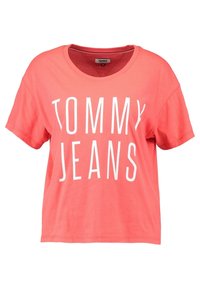 Korálová bavlněná tričko s kulatým výstřihem a krátkými rukávy, s výrazným bílým nápisem "TOMMY JEANS" přes přední část.