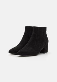 Black suede ankle boots with a pointed toe, chunky heel, and smooth texture. Side panel design detail adds visual interest.