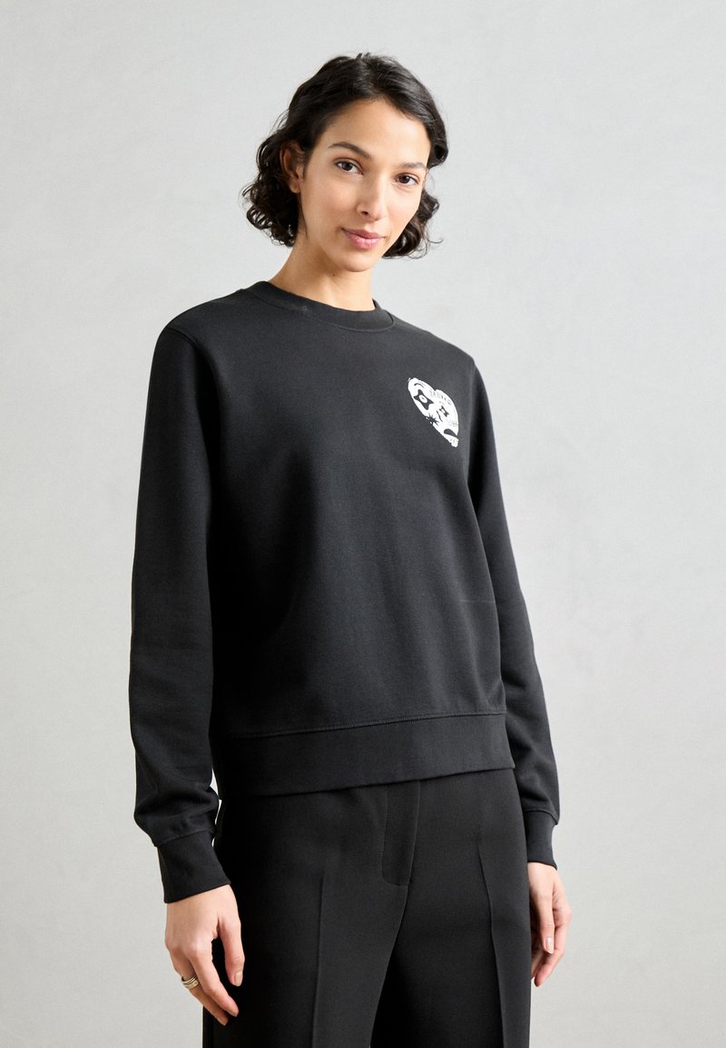 Czarny sweatshirt z okrągłym dekoltem i ściągaczami przy rękawach. Posiada biały nadruk graficzny na klatce piersiowej. Miękka, teksturowana tkanina.