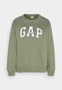 Felpa verde oliva con collo a giro, maniche lunghe e logo ricamato "GAP" in bianco sulla parte anteriore. Materiale in morbido tessuto di cotone misto.