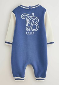 Blaues Baumwoll-Einsie mit langen, cremefarbenen Ärmeln, featuring ein weißes, geschwungenes "TB"-Logo und darunter den Text "BAKER", gestreifte Bündchen und einen runden Halsausschnitt.