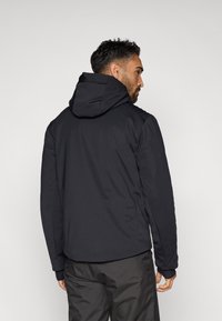 Čierna kapucňová bunda s hladkým, matným povrchom, ktorá má na chrbte vyvýšené logo a rebrové detaily na pleciach.