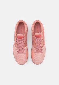 Różowe buty sportowe wykonane z połączenia gładkich i teksturowanych materiałów, z wyściełanym językiem, okrągłymi sznurowadłami i perforowanymi detalami.