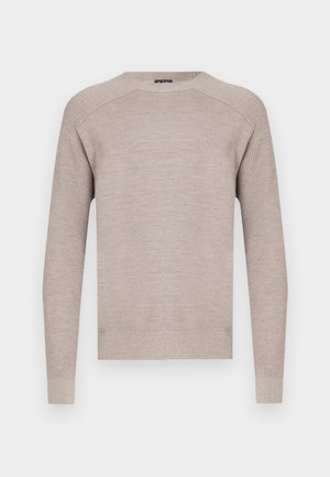 Smėlio spalvos megztinis su apvalia iškirpte, ilgomis rankovėmis ir ribotais rankogaliais bei apačia. Lygus paviršius su subtilia, vienoda rašto faktūra.