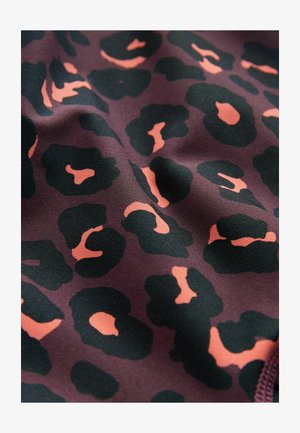 Gemusterter Stoff mit einem dunkelvioletten Hintergrund und schwarzen sowie pfirsichfarbenen Leopardenflecken. Glatte Textur mit leichtem Glanz.