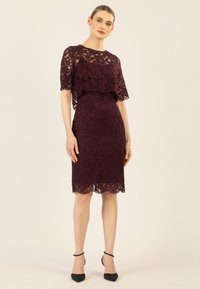 Bordeaux Spitzenkleid mit gewelltem Saum, das ein gestuftes Design und kurze Ärmel hat. Der Stoff besitzt ein detailliertes Blumenmuster.