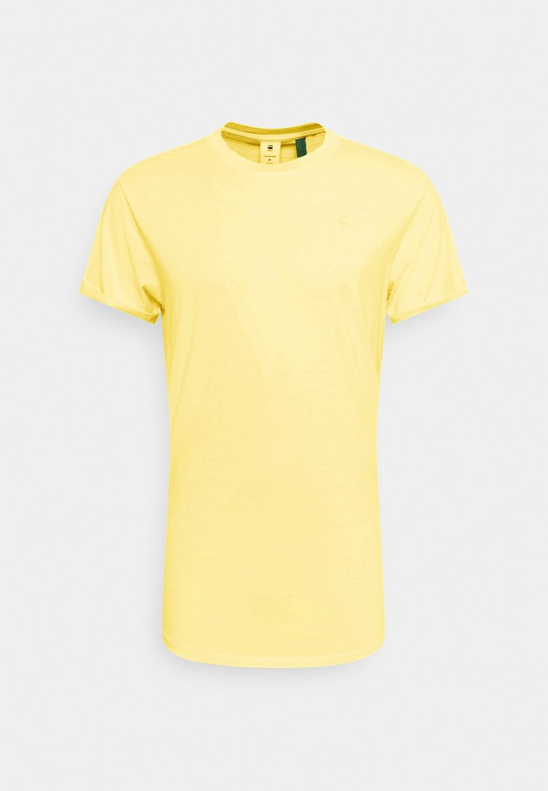 T-shirt jaune à manches courtes avec un col rond, fabriqué en tissu de coton doux. Il présente un ourlet droit et une étiquette de marque minimaliste au niveau du col.