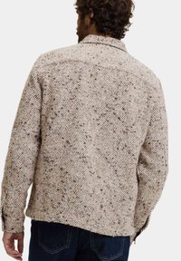 Beige en bruine flanellen blouse met een visgraatpatroon, met kraag, knoopmanchetten en een rechte snit. Gestructureerd oppervlak, ontspannen pasvorm.