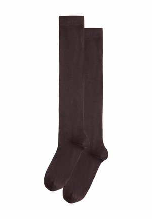 Paar schlichte dunkelbraune knielange Socken flach auf weißem Hintergrund ausgelegt.