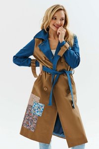 Trench coat w kolorze niebieskim u góry i beżowym na dole, z kwiatowymi naszywkami po lewej stronie. Zawiera pasek i podwójne zapięcie.