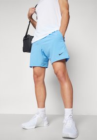 Nike miesten siniset shortsit, jotka on valmistettu kevyestä kankaasta. Niissä on joustava vyötärö, suora leikkaus ja pieni musta logo sivussa.