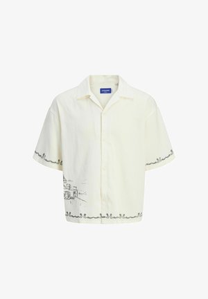 Kortärmad, ljus krämfärgad skjorta med krage, med en grå skissdesign på framsidan och dekorativa kantdetaljer.