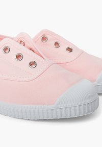Sneakers in tela rosa con punta e suola in gomma bianca. Presentano occhielli metallici per i lacci e una texture liscia.