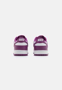 Sapatilhas Nike em couro roxo com detalhes brancos. Apresentam um colar almofadado, sola de borracha texturizada e logotipo em relevo no calcanhar.
