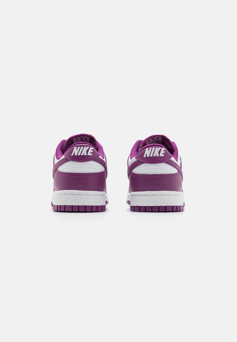 Zapatillas Nike de cuero púrpura con detalles en blanco. Presentan un collar acolchado, suela de goma texturizada y logo elevado en el talón.