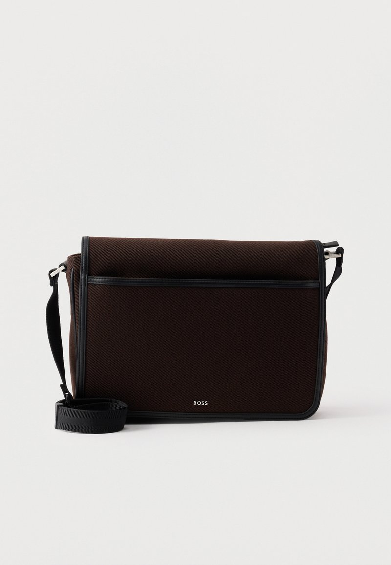 Τσάντα ταχυδρόμου από σκουρό καφέ ύφασμα με ρυθμιζόμενο μαύρο ιμάντα και μικρό ασημί λογότυπο "BOSS" στο μπροστινό καπάκι.