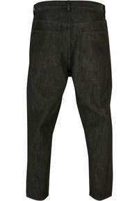 Pantalons en denim foncé avec une coupe fuselée, dotés de poches arrière et d'un motif uni. Le tissu a une texture lisse et peu de coutures.